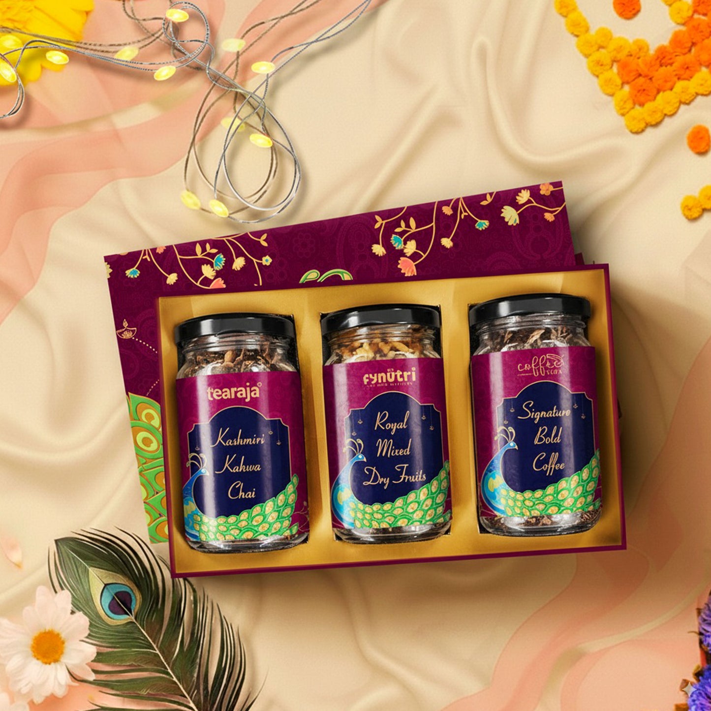 Peacock Diwali Box opened displaying three glass jars – Kashmiri Kahwa Chai, Signature Bold Coffee, and Mixed Dry Fruits – along with Happy Diwali card in gold-foiled themed packaging.”