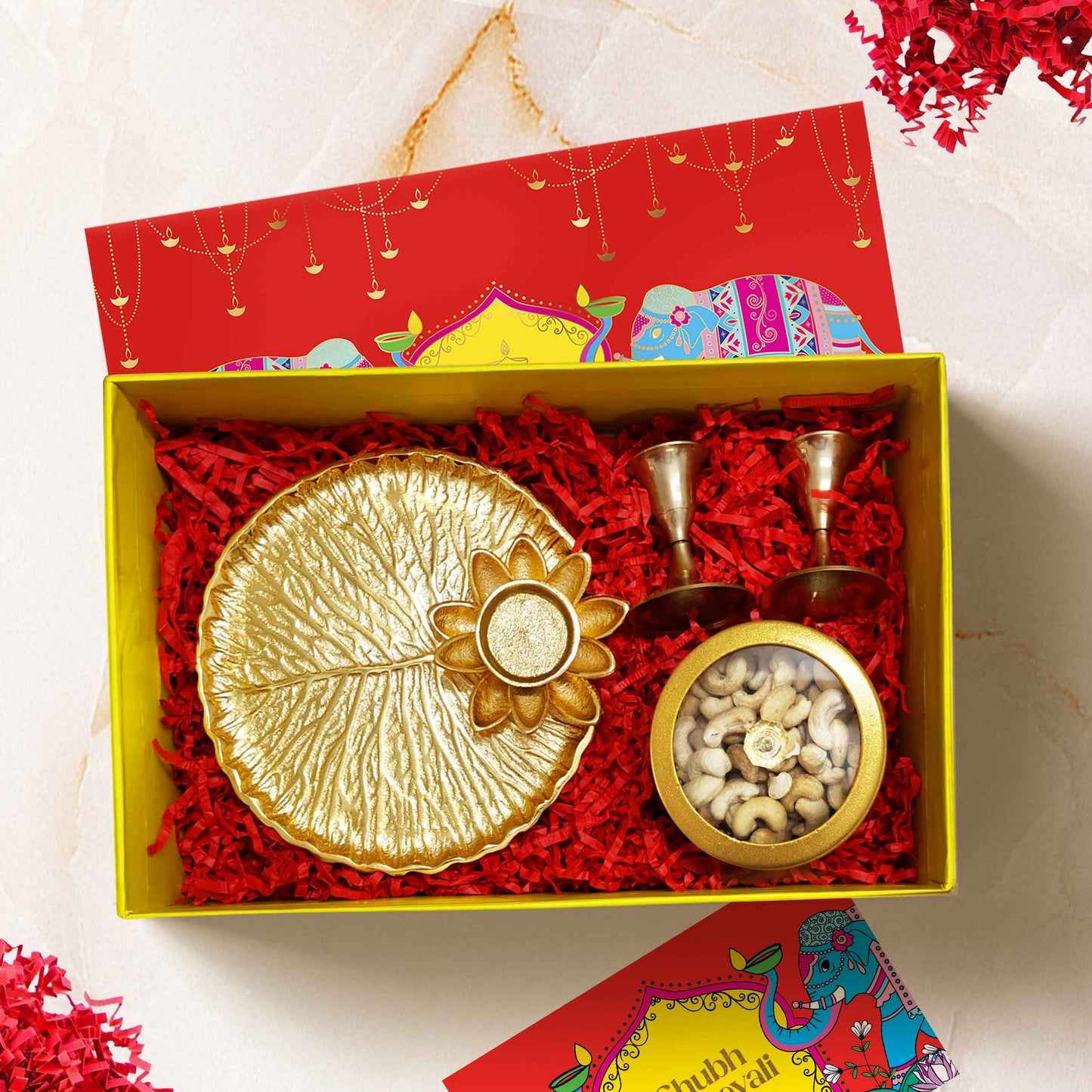Luxury Celestia Box Diwali gift hamper with brass candle stands, gold-tinted puja thali, and premium cashews