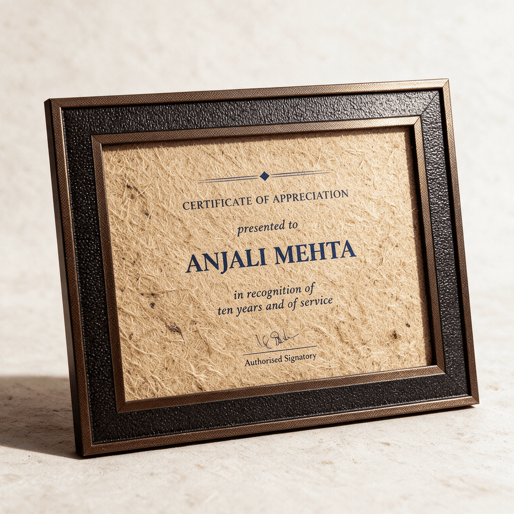 A4 certificate of appreciation printed on natural jute fibre in a bronze and black textured frame, standing against a pale wall