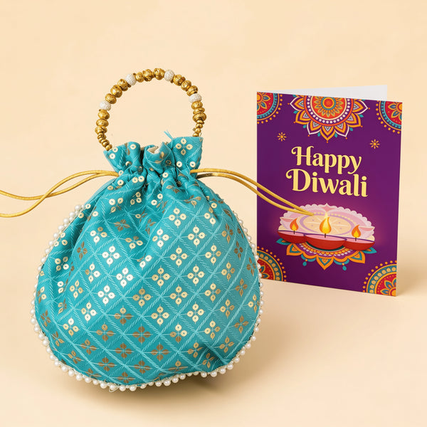 Turquoise hand-stitched Diwali potli gift bag with gold foil print, pearl bead trim and a gold beaded handle, standing beside a purple Happy Diwali greeting card