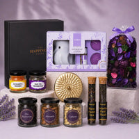 Luxury Diwali gift hamper with a black gift box, lavender vaporizer set, gold scented candle tin, violet potpourri bag, jars of dry blueberries, almonds and cashews, kesariya mishri, mouth freshener and two teas