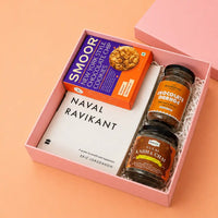 Rigid pink kappa board gift box seen at an angle with its separate lift-off lid to one side, packed with a book, two glass jars and a cookie carton