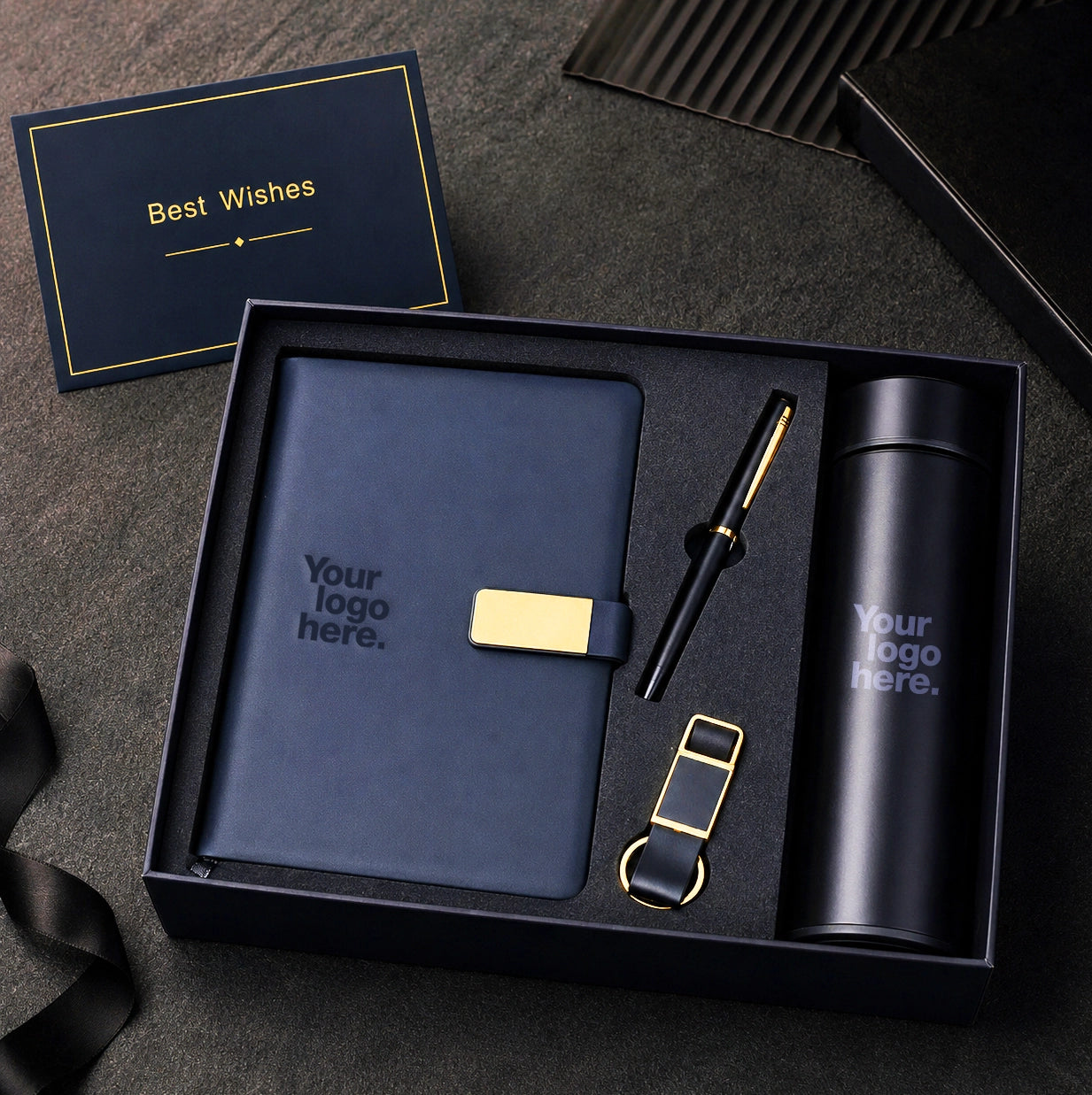 Navy corporate gift set with gold accents — notebook, pen, keychain and flask arranged in a premium navy presentation box