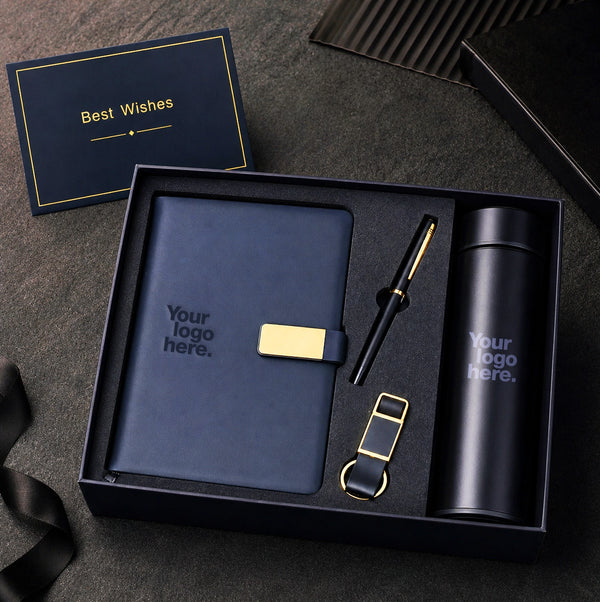 Navy corporate gift set with gold accents — notebook, pen, keychain and flask arranged in a premium navy presentation box