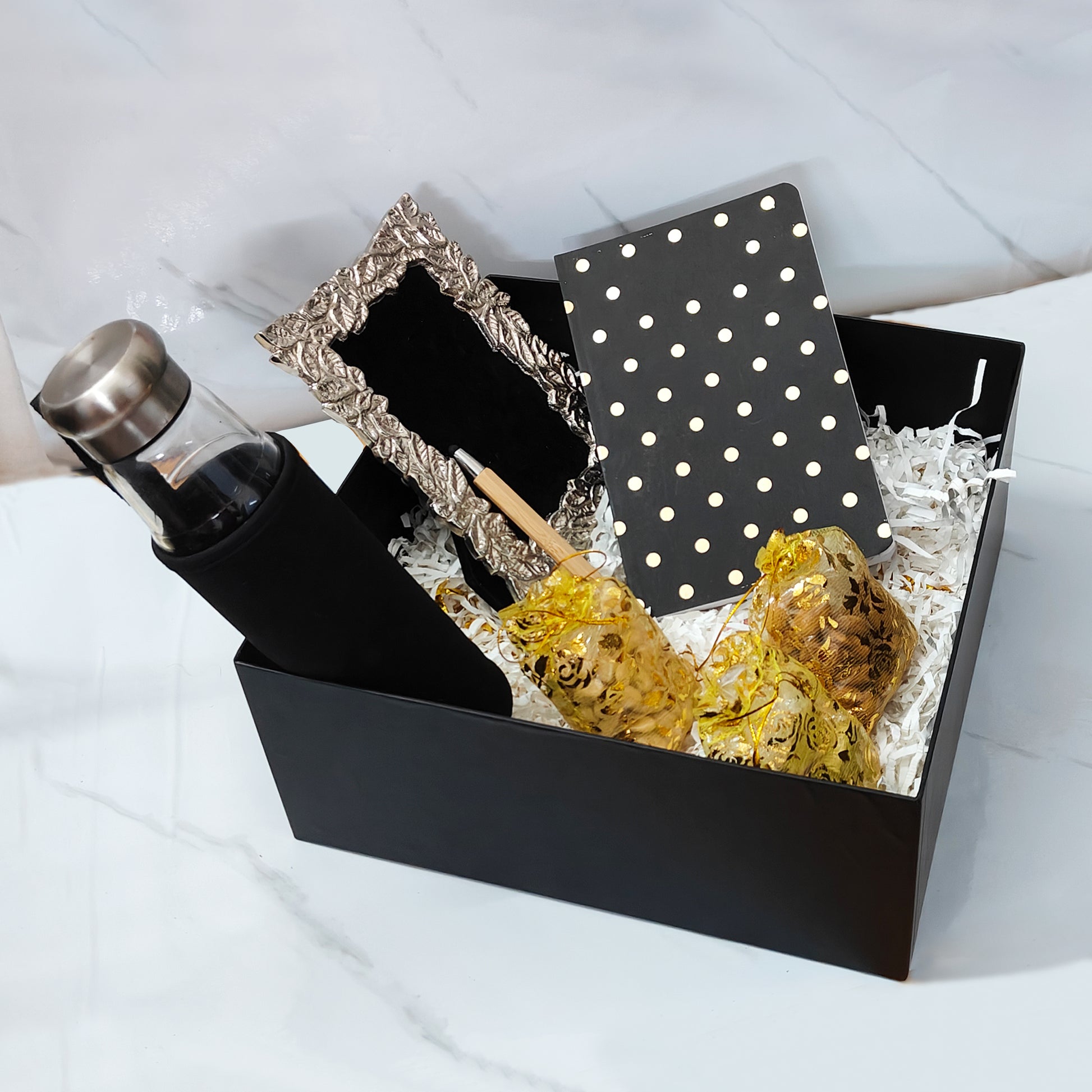 Close-up of Affinity Luxe Box branding and golden ribbon on black box
