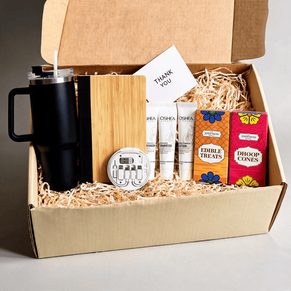Angled view of the open everyday gift hamper with the lid raised and a gift card standing among the contents