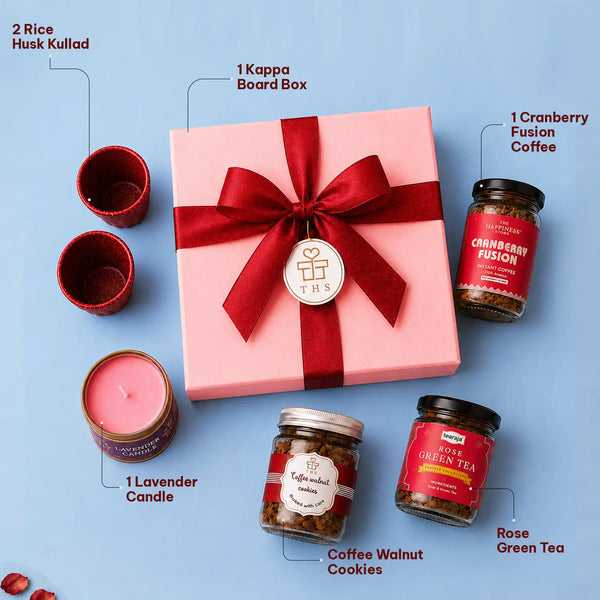 Labelled contents of the tea and coffee gift hamper — kappa board box with a red ribbon and wish tag, two rice husk kullads, a lavender candle, cranberry fusion instant coffee, coffee walnut cookies and rose green tea