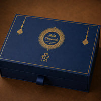 Closed navy Diwali gift box with a gold-foil Shubh Deepawali mandala, hanging jhumar motifs, a gold rule border and a navy ribbon pull tab on a drawer-style base