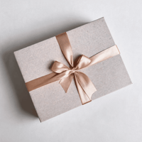 Closed kraft gift hamper box tied with a satin ribbon and bow, ready to gift