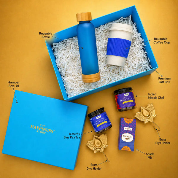 Labelled contents of the Diwali tea hamper — premium gift box and lid, reusable frosted glass bottle, reusable wheat straw coffee cup, butterfly blue pea tea, Indian masala chai, snack mix and two brass diya holders
