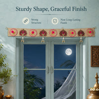 Jute lotus toran mounted above a window at night, showing the natural jute band, its nine alternating motifs and four pearl-bead drops