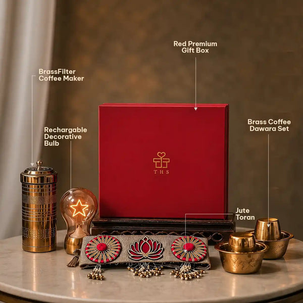 Labelled contents of the brass Diwali hamper: red keepsake box, etched brass coffee filter, rechargeable star bulb, dabara tumbler and bowl pair and jute toran