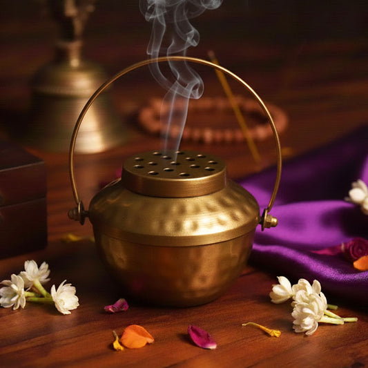 Golden loban burner with handle, emitting smoke – pooja and Diwali rituals