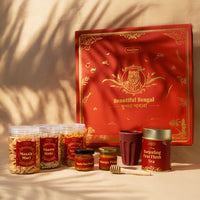 All contents of the Beautiful Bengal Box gift hamper — Bengal-sourced snacks, tea, honey, eco rice husk cup and wooden honey comb


