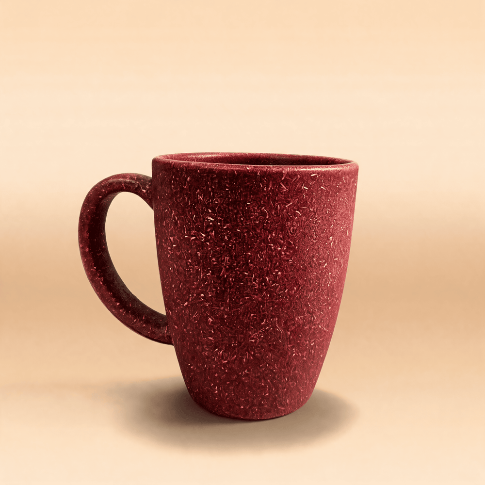 Wine crimson rice husk coffee mug with a closed loop handle, shown three-quarter on a warm neutral surface