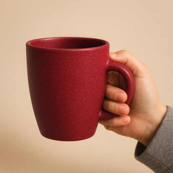 350ml rice husk mug held in an adult hand, fingers through the handle, showing its true size 