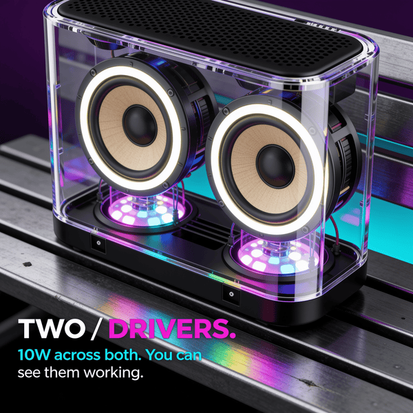 Close view through the clear wall of the Bluetooth speaker showing its two drivers and the RGB light rings beneath them, 10W across both