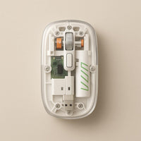 Top view of the white transparent wireless mouse showing the green circuit board, rechargeable cell and the USB receiver stowed inside the body